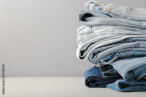 stack of blue jeans on light background