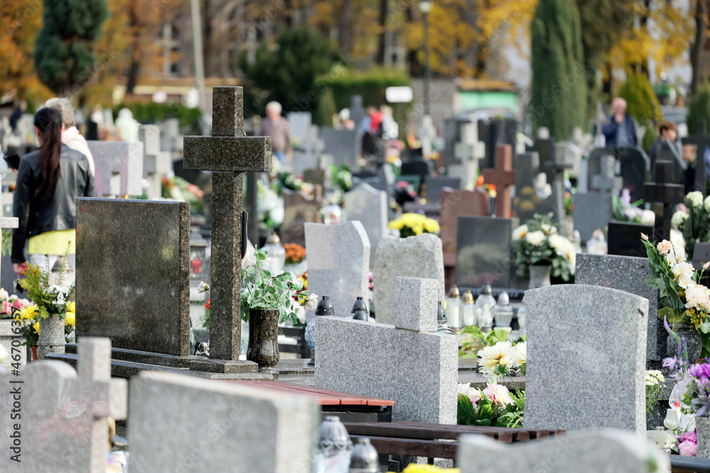 Szereg grobów na cmentarzu  w czasie święta zmarłych. - obrazy, fototapety, plakaty 