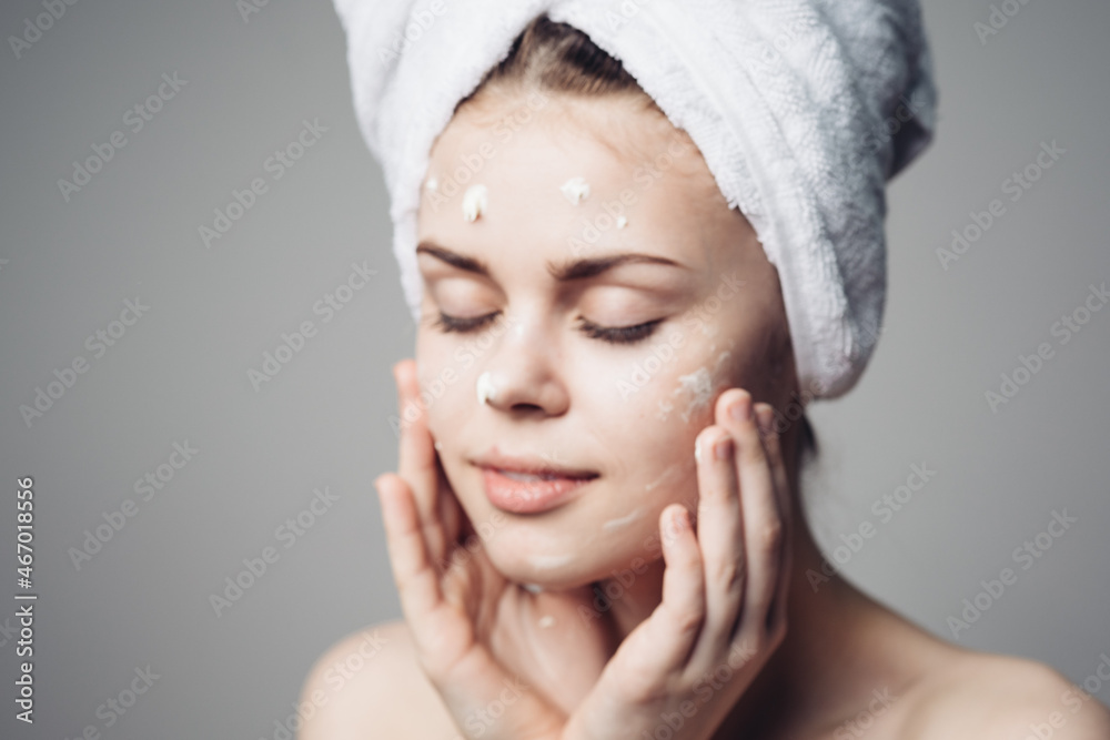 woman with bare shoulders towel on head face cream skin care woman with bare shoulders towel on head face cream skin care