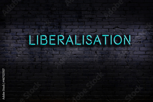 Φωτογραφία Night view of neon sign on brick wall with inscription liberalisation