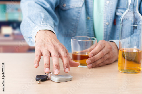 Fotografie Man hand drinking beer and holding car keys