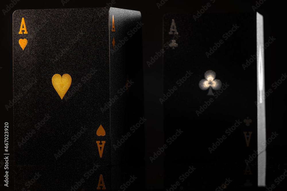 Obraz premium Black poker cards on a black background. Stylish composition. Casino, online casino, gambling, poker, gambling business, game strategy, luxury, risk, cash flow, hobby.