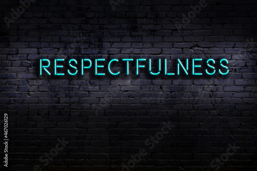 Neon sign. Word respectfulness against brick wall. Night view