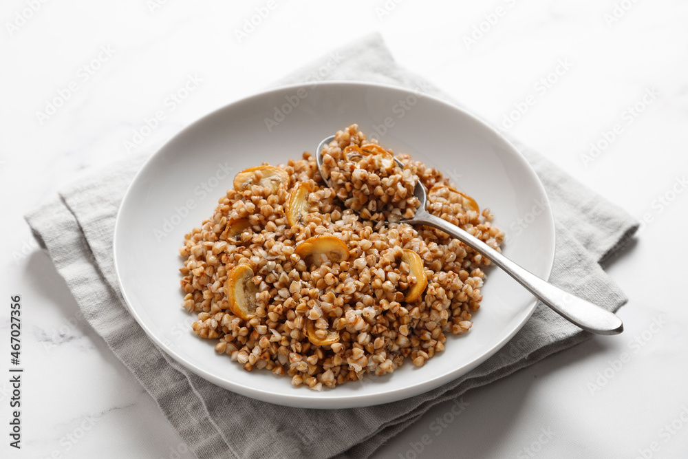 boiled buckwheat porridge with mushrooms with a spoon on napkin boiled buckwheat porridge with mushrooms with a spoon on napkin
