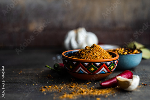 Bowl of adjika spice with dried chilli, chilli peppers, salt, garlic and bay leaves on a  table photo