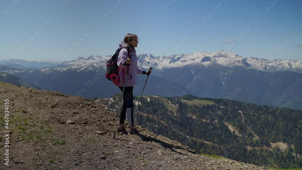 Inspired woman hiker is amazed with mountain scenery Inspired woman hiker is amazed with mountain scenery