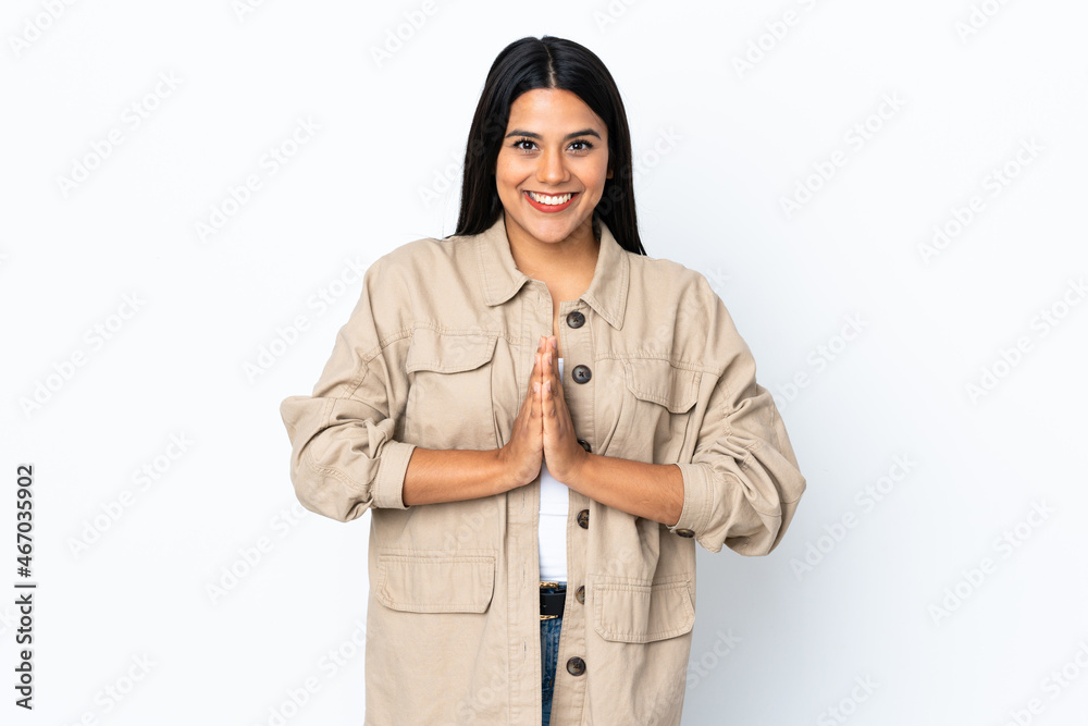 Young latin woman woman isolated on white background keeps palm together. Person asks for something Young latin woman woman isolated on white background keeps palm together. Person asks for something