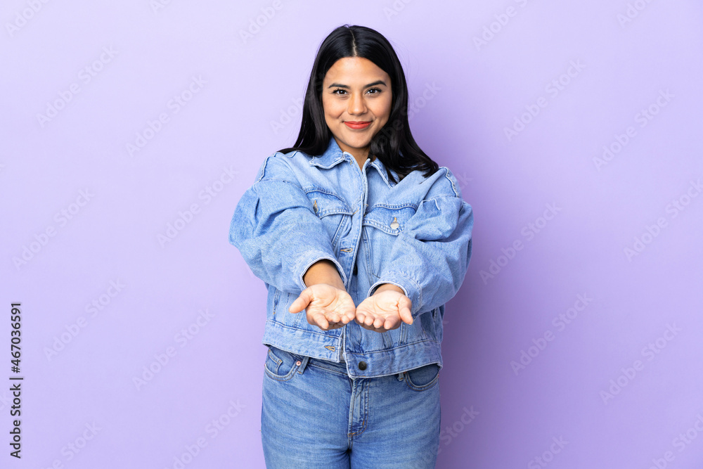Young latin woman woman over isolated background holding copyspace imaginary on the palm to insert an ad Young latin woman woman over isolated background holding copyspace imaginary on the palm to insert an ad
