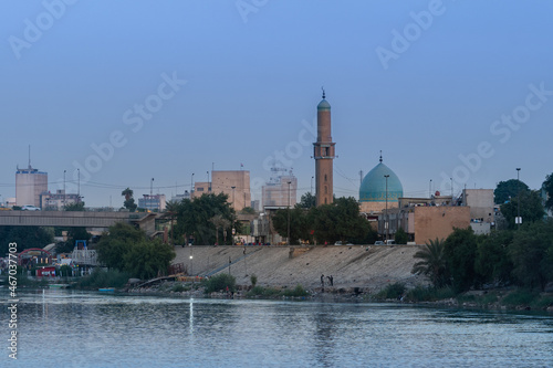 Baghdad, Iraq - October 11, 2021: Evening View of Al Takarta Mosque Overlooking on Tigris River with the Great Gate Bridge in Background Located in Haifaa Street in Baghdad.