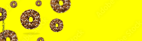Glazed brown sweet sugar chocolate doughnut donut dessert on yellow pastel background banner. Creative minimal blurred selective focus collage food concept