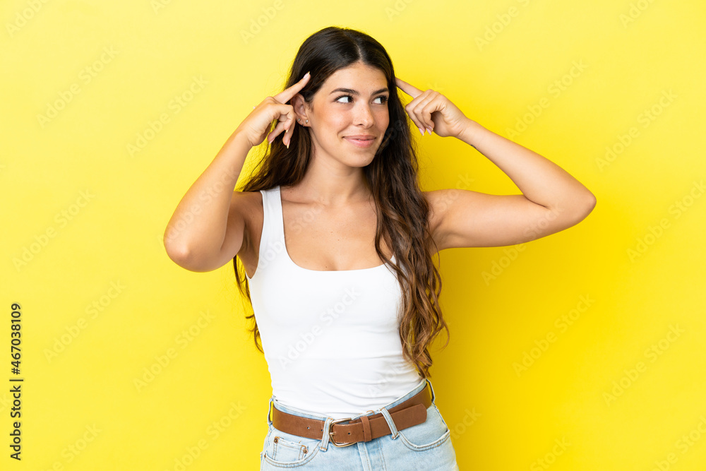 Young caucasian woman isolated on yellow background having doubts and thinking Young caucasian woman isolated on yellow background having doubts and thinking