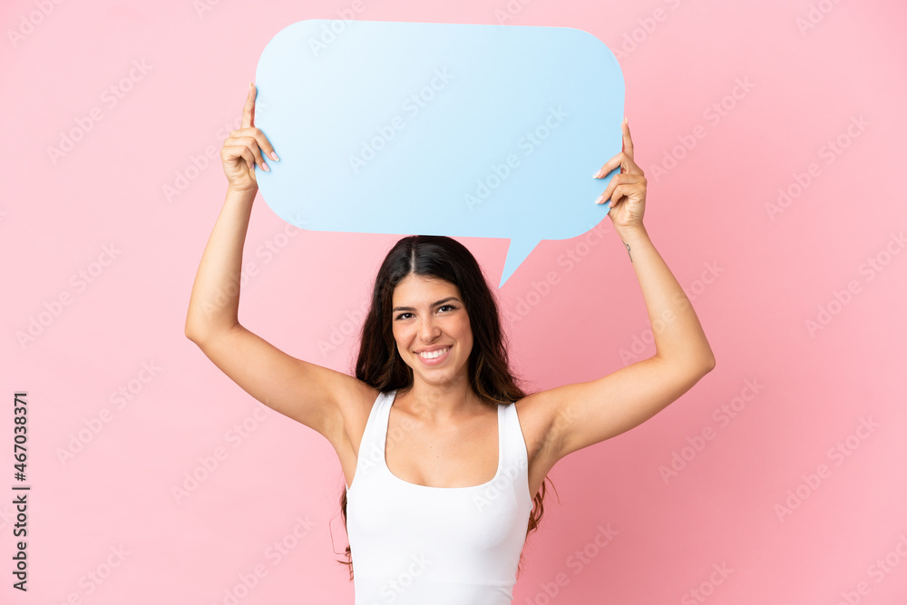 Young caucasian woman isolated on pink background holding an empty speech bubble Young caucasian woman isolated on pink background holding an empty speech bubble