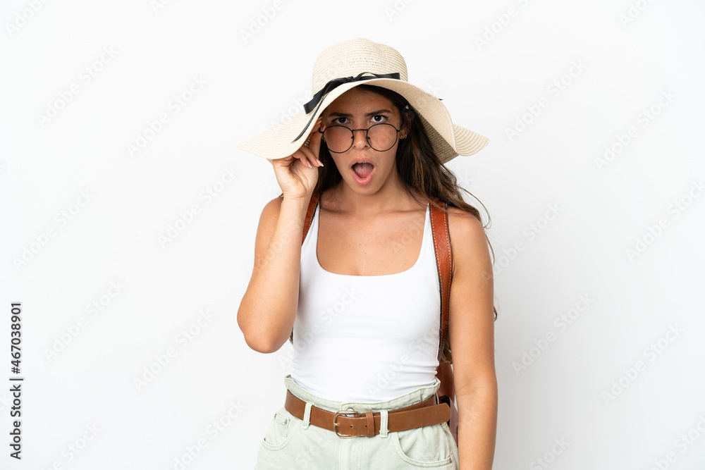Young caucasian woman wearing a Pamela in summer holidays isolated on white background with glasses and surprised Young caucasian woman wearing a Pamela in summer holidays isolated on white background with glasses and surprised