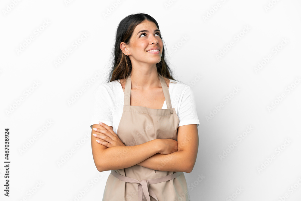 Restaurant waiter over isolated white background looking up while smiling Restaurant waiter over isolated white background looking up while smiling