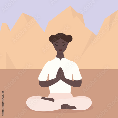 A young African-American woman does yoga among the mountains. The girl is sitting in the lotus position in nature. Playing sports on the street. Relaxation and detox from city life