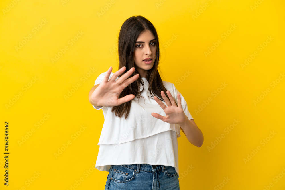 Young caucasian woman isolated on yellow background nervous stretching hands to the front Young caucasian woman isolated on yellow background nervous stretching hands to the front