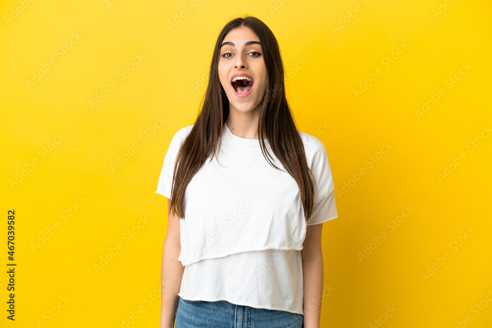 Young caucasian woman isolated on yellow background with surprise facial expression
