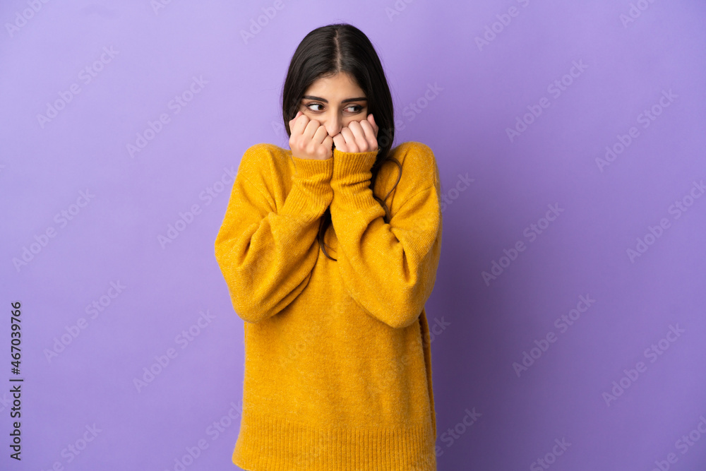 Young caucasian woman isolated on purple background nervous and scared putting hands to mouth Young caucasian woman isolated on purple background nervous and scared putting hands to mouth