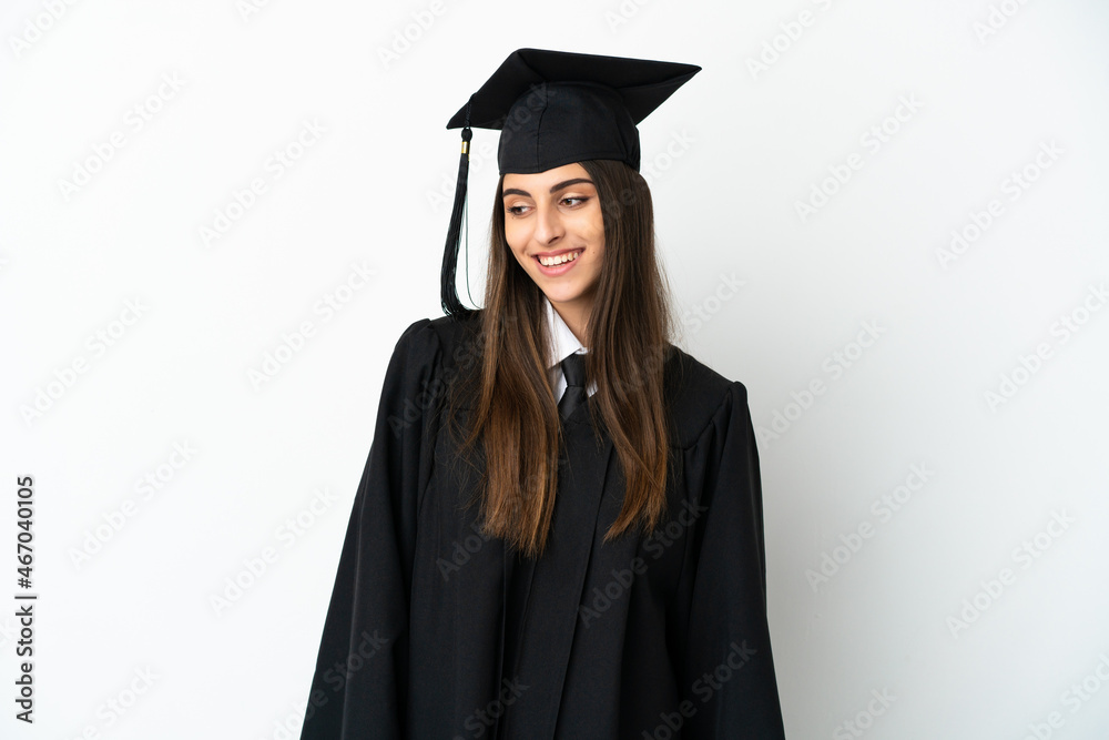 Young university graduate isolated on white background looking to the side and smiling Young university graduate isolated on white background looking to the side and smiling