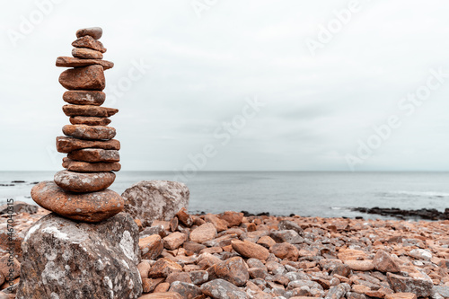 Balancing stones on the rocky coast of Hovs Hallar nature reserve in Sweden. Blurred background. Selective focus.