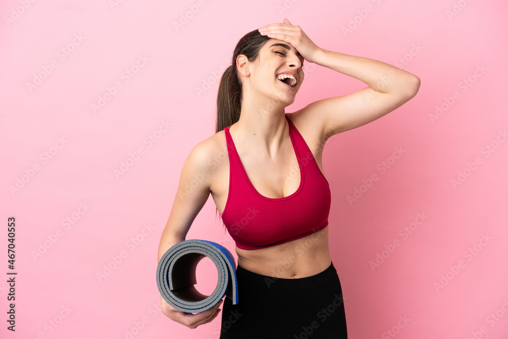 Young sport caucasian woman going to yoga classes while holding a mat smiling a lot Young sport caucasian woman going to yoga classes while holding a mat smiling a lot