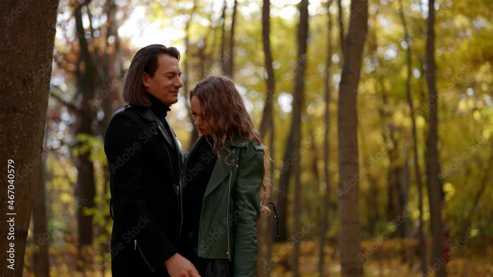 pretty woman is flirting with her boyfriend in park in fall day, dancing and snuggling pretty woman is flirting with her boyfriend in park in fall day, dancing and snuggling