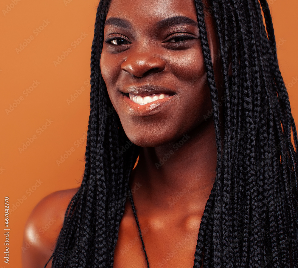 pretty young african american woman with braids posing cheerful gesturing on brown background, lifestyle people concept