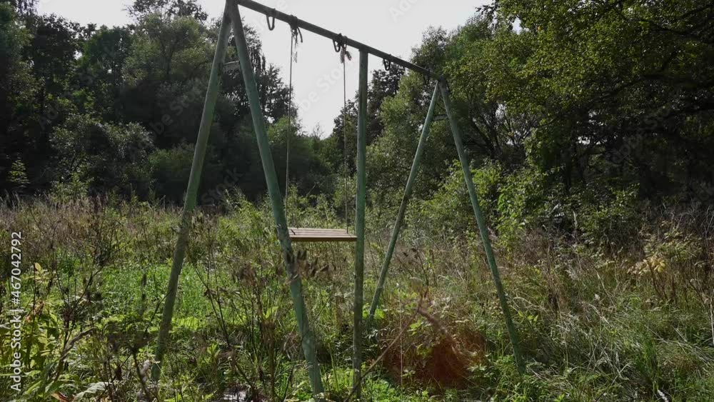 An empty abandoned swing in the forest. The concept of loneliness and time. Video. High quality 4k footage An empty abandoned swing in the forest. The concept of loneliness and time. Video. High quality 4k footage