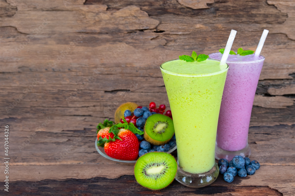 Kiwi strawberry and blueberry smoothies colorful fruit juice green purple and red milkshake blend beverage healthy high protein the taste yummy In glass drink episode morning on wood background. Kiwi strawberry and blueberry smoothies colorful fruit juice green purple and red milkshake blend beverage healthy high protein the taste yummy In glass drink episode morning on wood background.