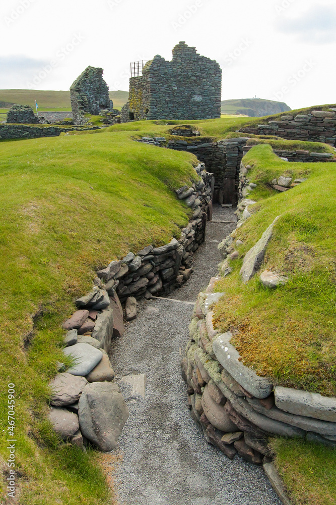Φωτογραφία Deep pathway surrounded with stone walls covered by green grass leading to the L