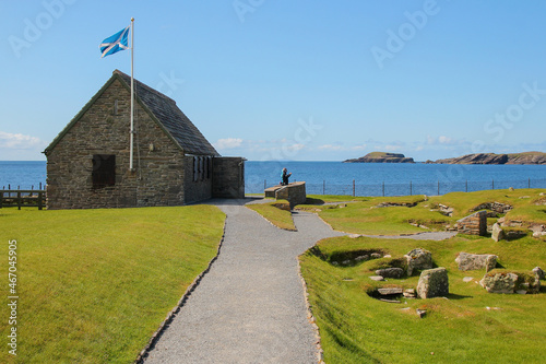 Visitor center with a Scottish flag at the Jarlshof Prehistoric and Norse settlement in the Shetland Islands, Scotland, near the North Sea