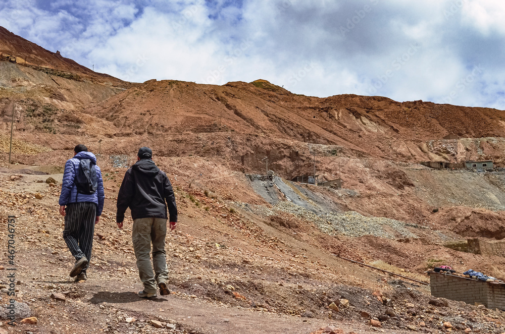 Back view of male tourists walking trough silver mines of Cerro Rico in Potosi, Bolivia, South America. The richest mine of the colonial exploitation in the Spanish conquest in Latin America 