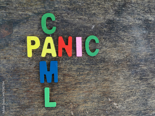 Cross word calm panic made of colourful wooden alphabet against wooden background.