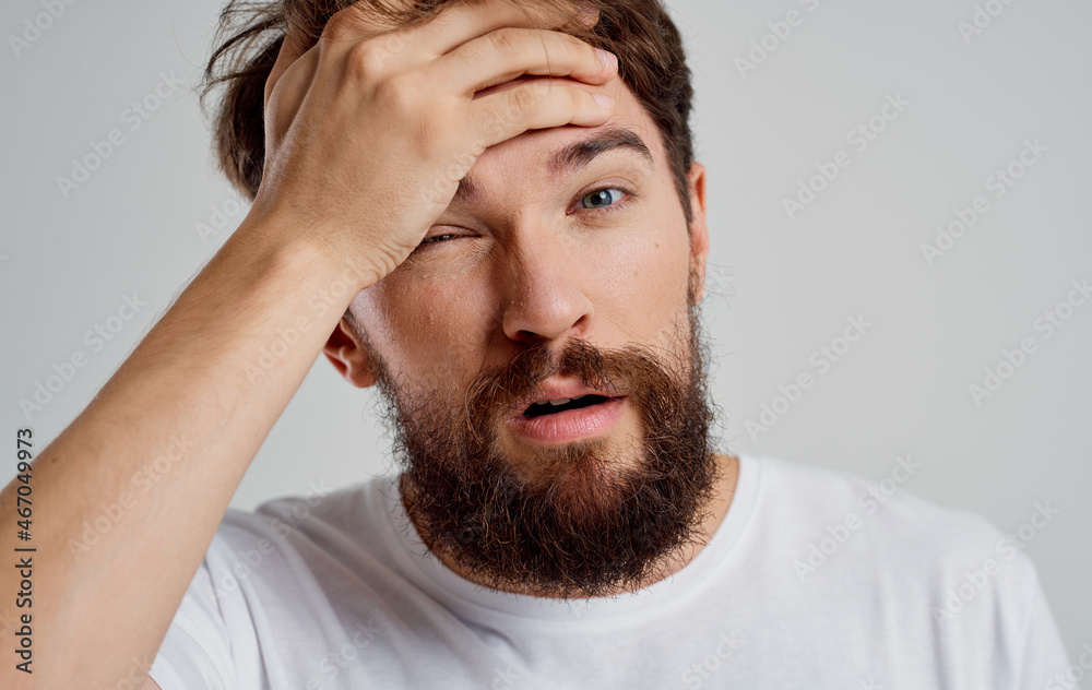 emotional man in a white t-shirt headache migraine problems light background emotional man in a white t-shirt headache migraine problems light background