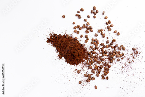 Um punhado de café moído misturado com grãos de café sob a mesa branca