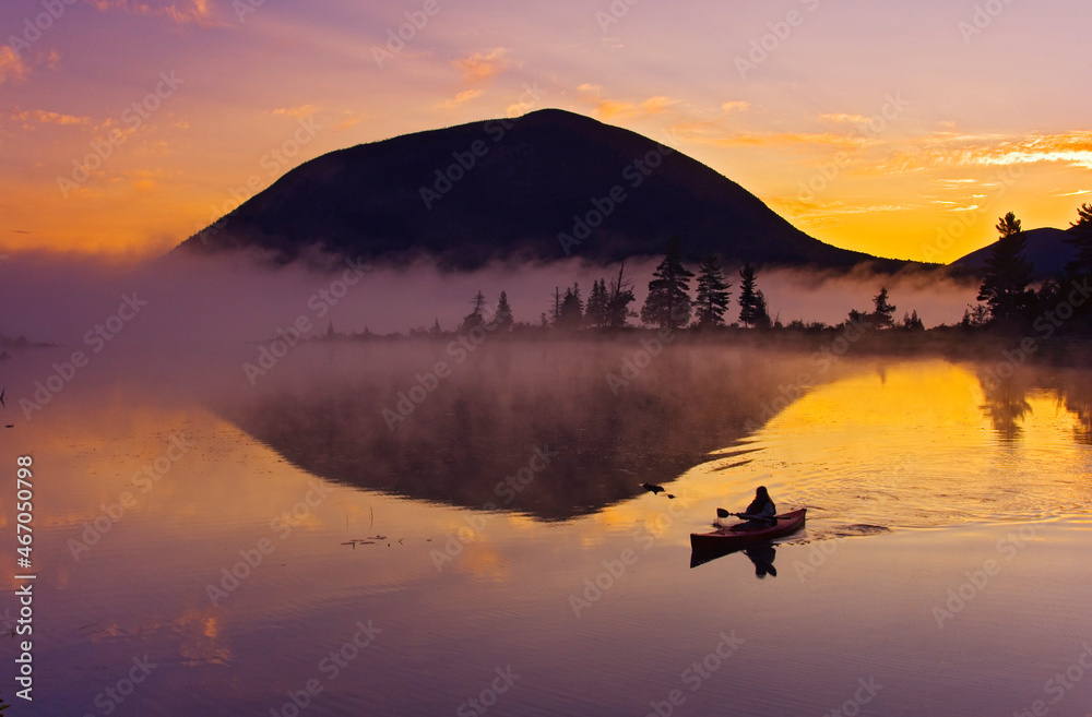 Sarah Brownell kayaking on Spencer Pond in front of Little Spencer Mountain, near Moosehead Lake, Maine USA