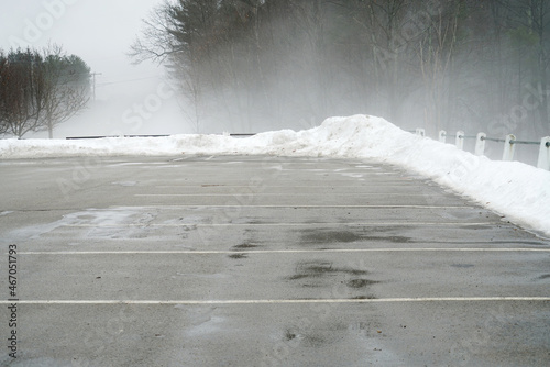empty parking lot with fog in winter morning with snow removal