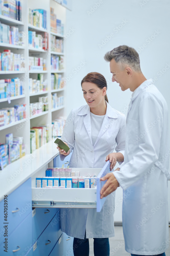 Man and woman in white coats with medicines