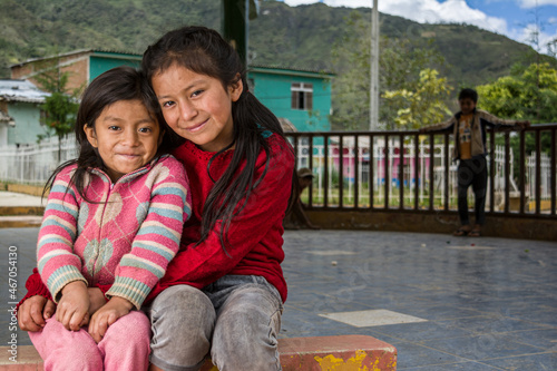 niñas Latinoamericanas andinas abrazándose y sonrriendo  photo