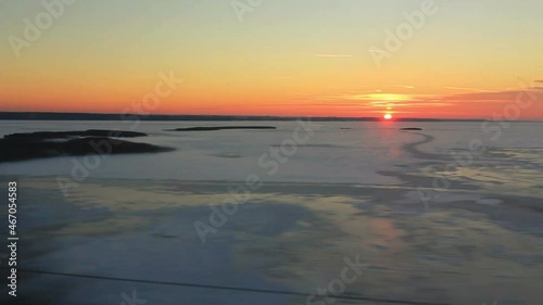 View from the window on the high-speed train Sapsan huge frozen lake at sunset. In shot there is also a home (POV) photo