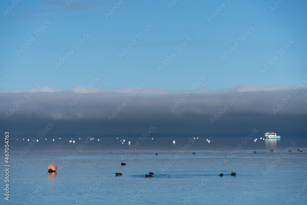 Bouys off shore on Lake Tahoe on a calm winter morning with a cloud bank in the distance