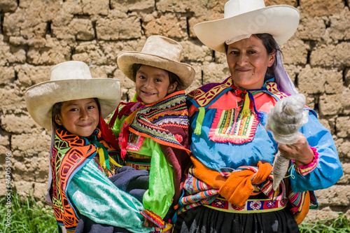 Картината върху платно Mujer madre latinoamericana andina haciendo hilo de lana de oveja y enseñando el telar de cintura a sus hijas