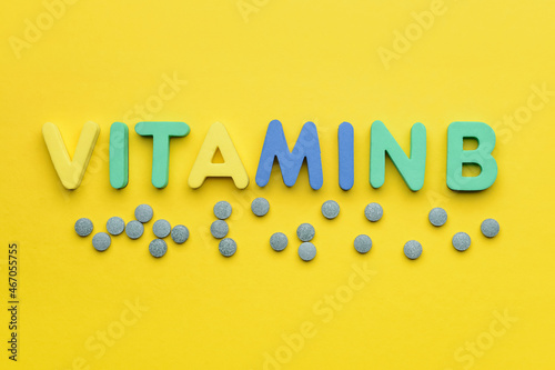 Text VITAMIN B with pills on color background photo