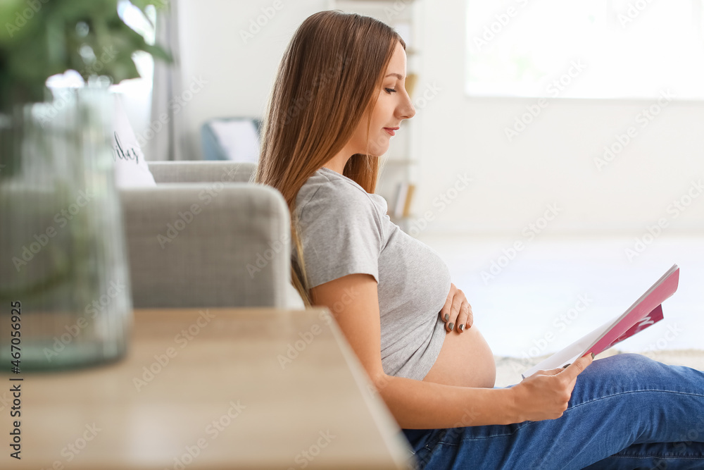 Young pregnant woman reading fashion magazine at home Young pregnant woman reading fashion magazine at home