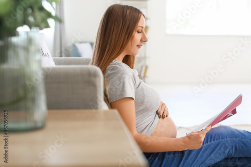 Young pregnant woman readin...