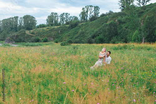 Happy romantic inloved couple looking at each other on a field outdoors. photo