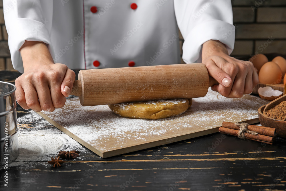 Confectioner rolling out gingerbread dough on table Confectioner rolling out gingerbread dough on table