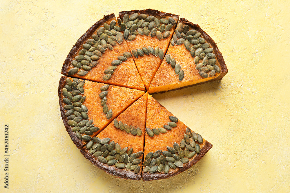Cut pumpkin pie on yellow background