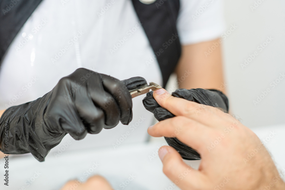 Manicure master cutting cuticles of male hands in beauty salon. Beauty industry concept Manicure master cutting cuticles of male hands in beauty salon. Beauty industry concept