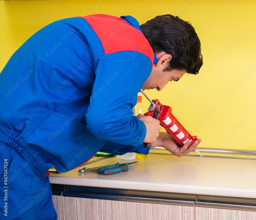 Fototapeta premium Repairman working in the kitchen